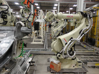 Industrial robotic arms with NACHI branding in automated manufacturing facility