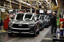 Infiniti luxury vehicles on assembly line in manufacturing plant with workers and industrial equipment