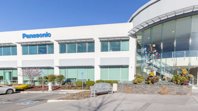 Panasonic corporate office building with modern white facade and curved glass entrance under clear blue sky