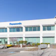 Panasonic corporate office building with modern white facade and curved glass entrance under clear blue sky