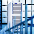 Modern data center with server racks and glass architecture in blue-toned lighting