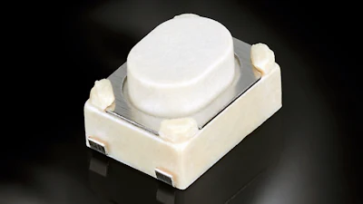 White tactile push button switch with metallic contact plate on dark background