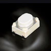 White tactile push button switch with metallic contact plate on dark background