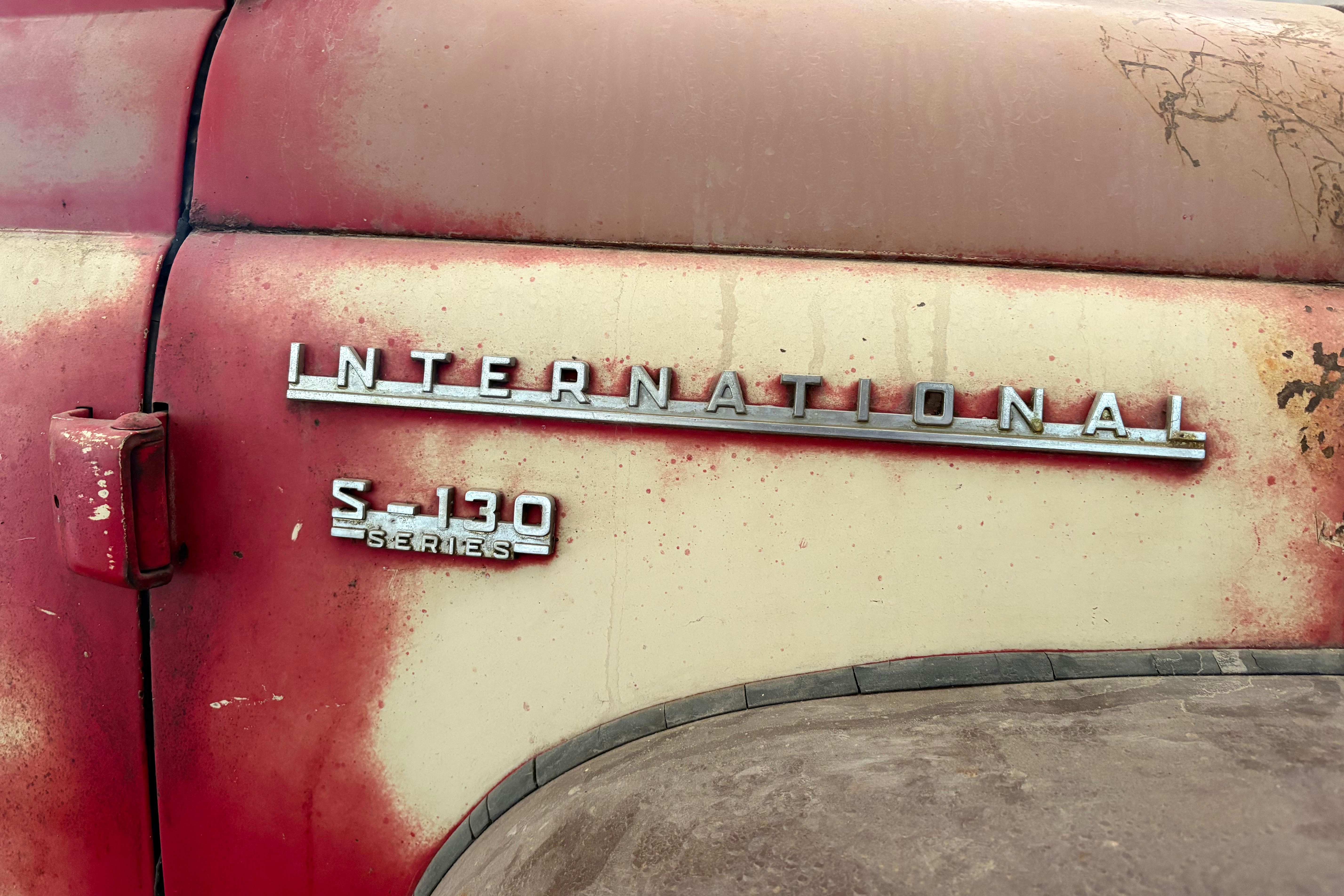 Vintage International Harvester S-130 Series truck badging on weathered red and cream painted vehicle door