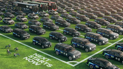 Large fleet of black police vehicles parked in organized rows on grass with white line markings and officers visible in the foreground.