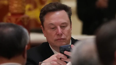 Man in business suit reviewing smartphone during formal meeting or event