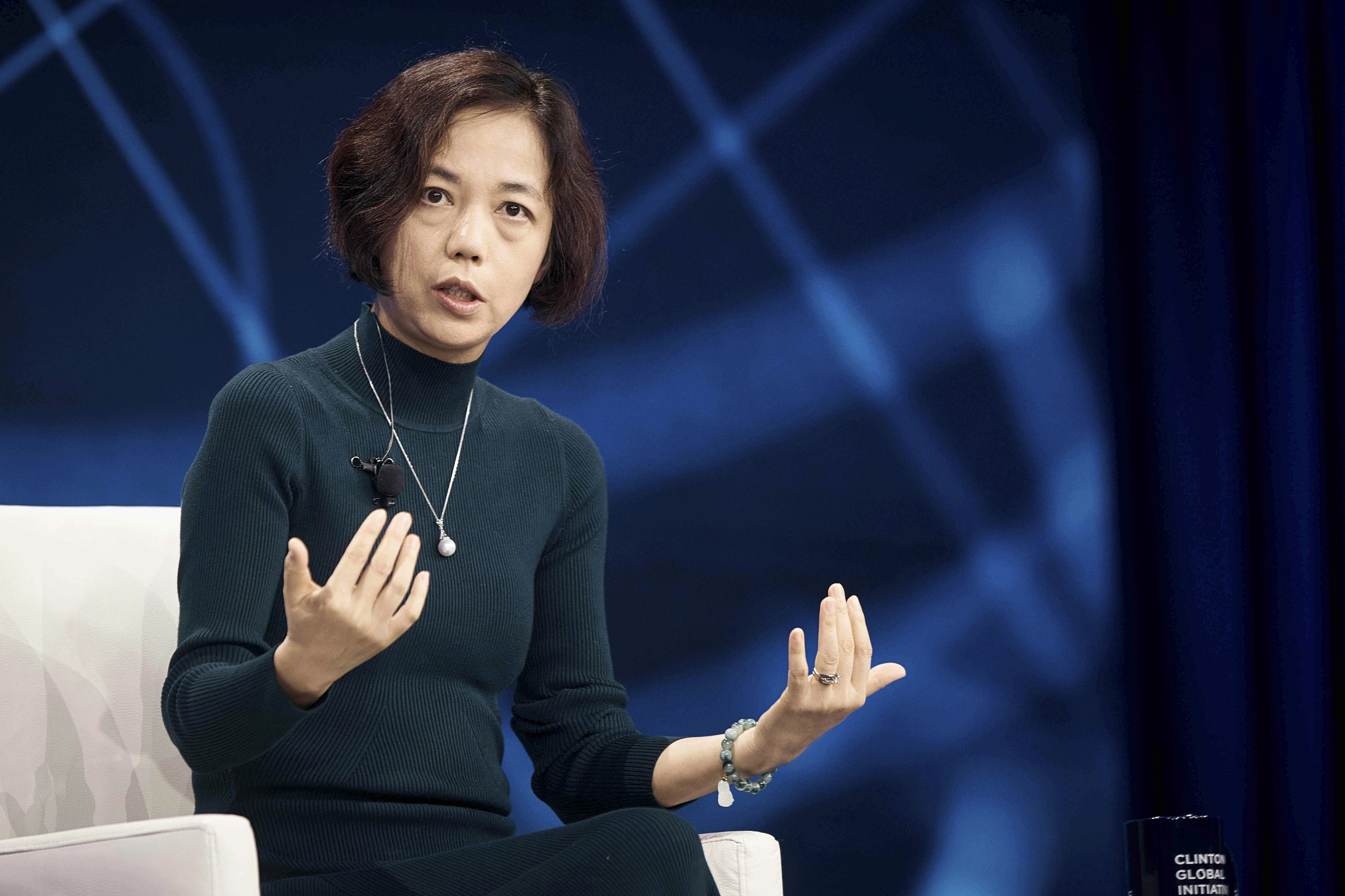 Professional woman speaking at conference with blue abstract background