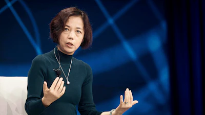 Professional woman speaking at conference with blue abstract background