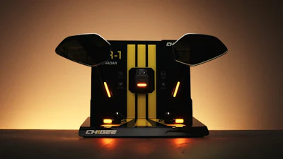 CHIDEZ gaming device with black wings, gold center stripe, and orange LED lighting on dark surface