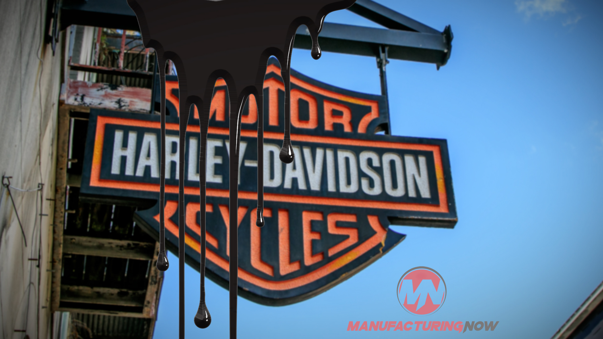 Harley-Davidson orange and black shield logo on storefront sign with clear blue sky