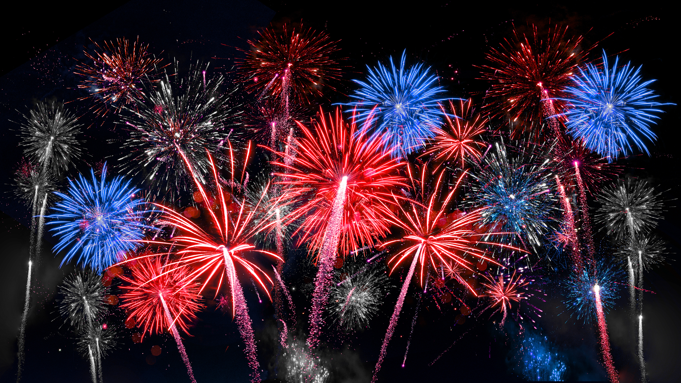 Colorful fireworks exploding in night sky with red, blue, and white bursts