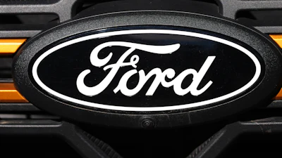 Ford oval logo on vehicle front grille with orange accent lighting