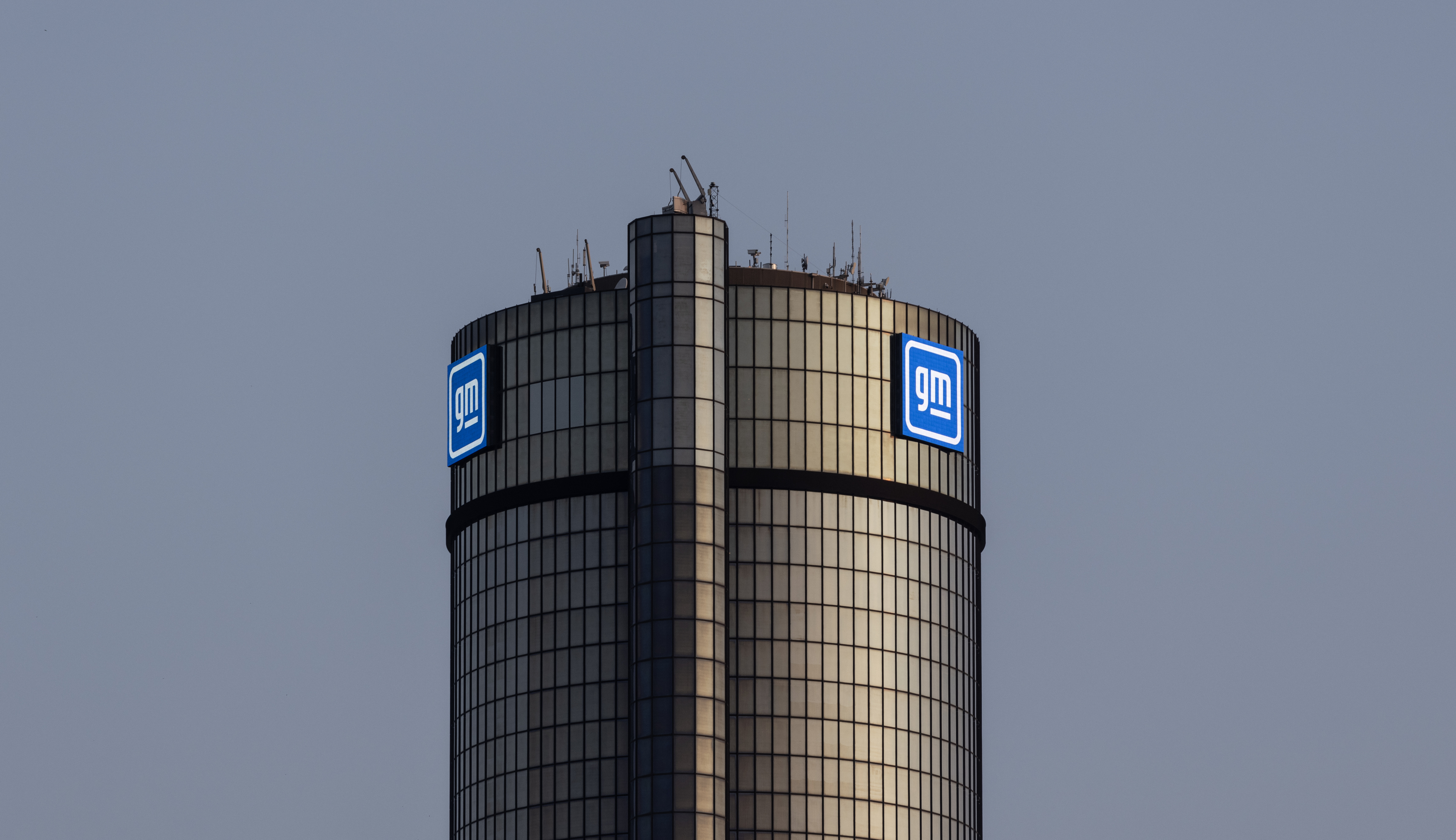 GM logo on cylindrical corporate tower against blue sky