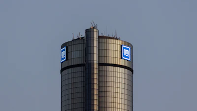 GM logo on cylindrical corporate tower against blue sky