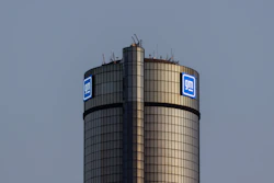 GM logo on cylindrical corporate tower against blue sky