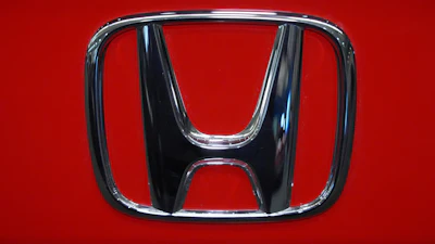 Honda logo emblem on red vehicle surface