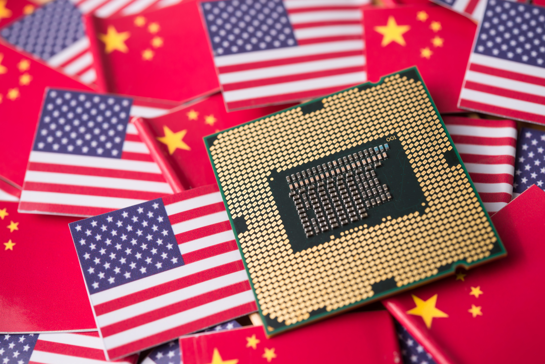Computer processor chip on American and Chinese flags symbolizing technology trade relations
