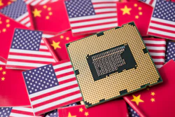 Computer processor chip on American and Chinese flags symbolizing technology trade relations