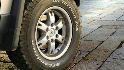 BFGoodrich all-terrain tire mounted on silver alloy wheel of parked vehicle