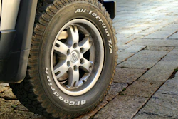 BFGoodrich all-terrain tire mounted on silver alloy wheel of parked vehicle