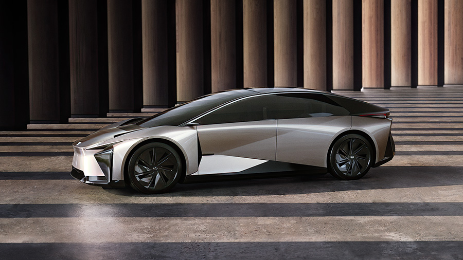 Silver Lexus LF-Z concept electric vehicle displayed in profile against modern columned architecture
