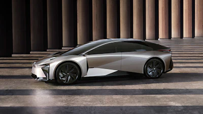 Silver Lexus LF-Z concept electric vehicle displayed in profile against modern columned architecture