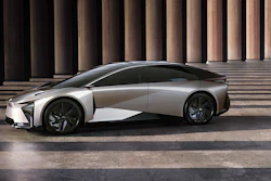Silver Lexus LF-Z concept electric vehicle displayed in profile against modern columned architecture