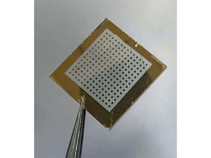 Perforated metal acoustic panel with brass frame and attached wiring cables