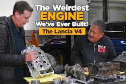 Two mechanics examine a Lancia V4 engine block in a workshop during an automotive documentary discussion.