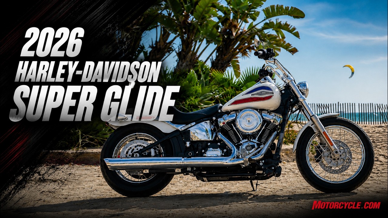 2026 Harley-Davidson Super Glide motorcycle with red, white, and blue paint displayed on sandy terrain with palm trees and ocean backdrop