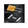 Yellow PTC thermistor fuse with white leads and black SMD 7030 resistor component on dark background