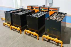 Industrial forklift battery units with yellow pallets arranged in warehouse facility