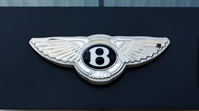 Bentley Motors winged 'B' emblem mounted on dark exterior surface