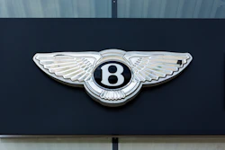 Bentley Motors winged 'B' emblem mounted on dark exterior surface