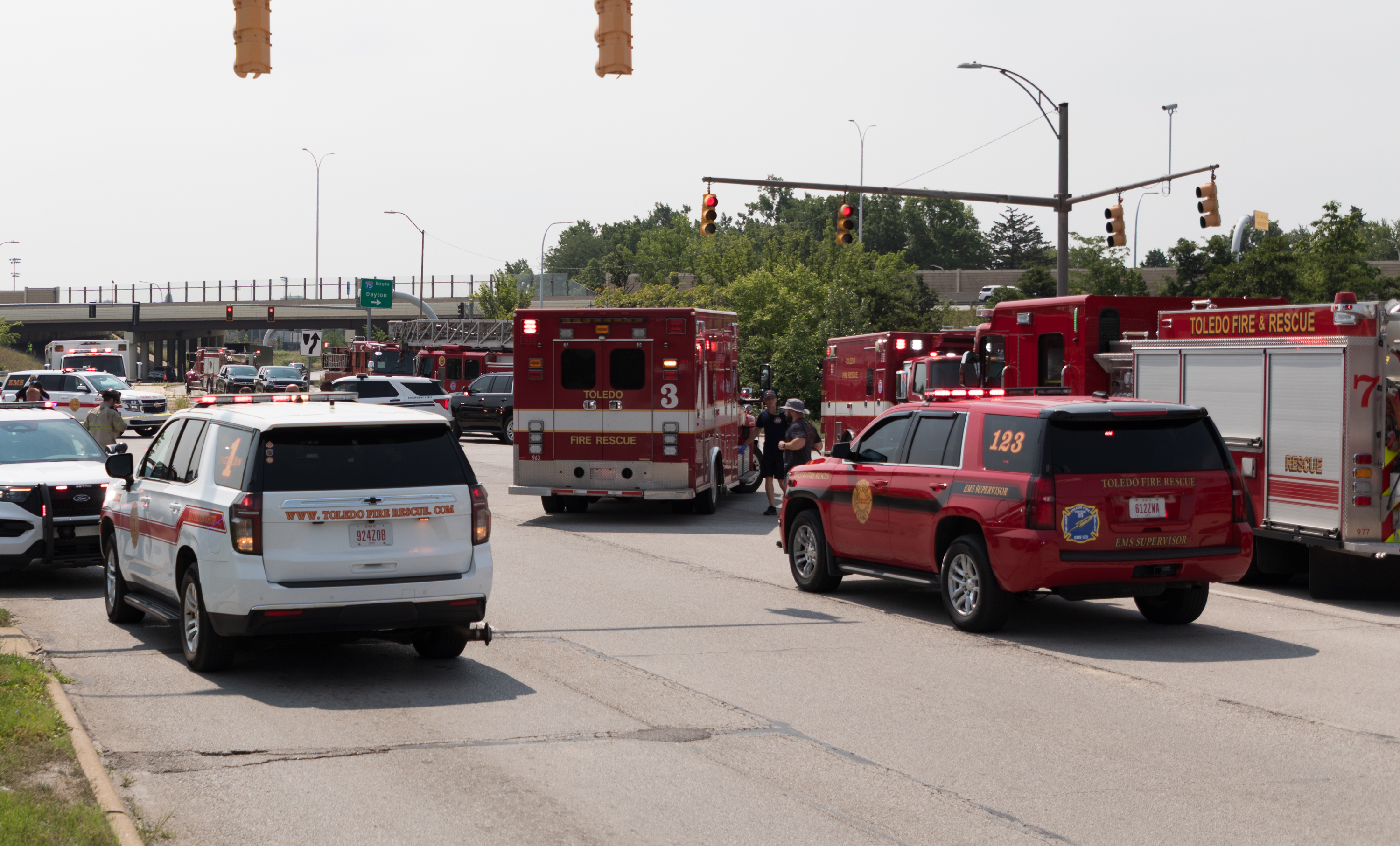 Fire rescue trucks and emergency vehicles lined up at urban intersection during daytime