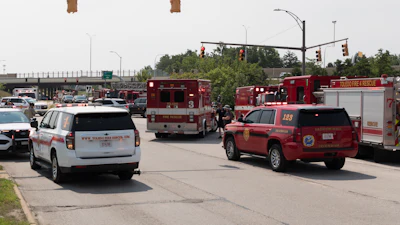 Fire rescue trucks and emergency vehicles lined up at urban intersection during daytime