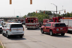 Fire rescue trucks and emergency vehicles lined up at urban intersection during daytime