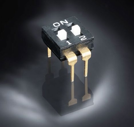 Black DIP switch with two gold pins and ON/1/2 position markings
