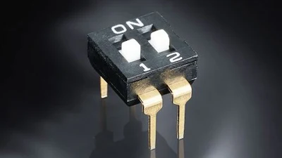 Black DIP switch with two gold pins and ON/1/2 position markings