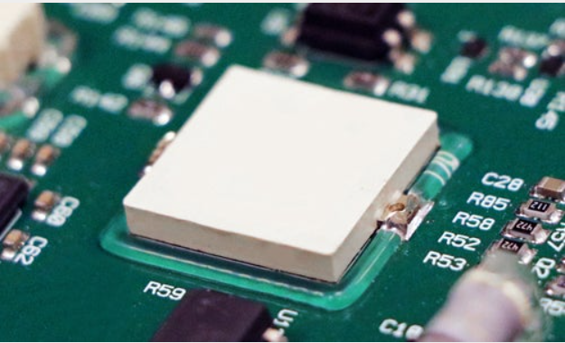 White heat sink mounted on green computer circuit board with electronic components