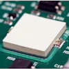 White heat sink mounted on green computer circuit board with electronic components