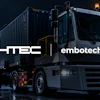 HTEC and Embotech branded commercial truck with cargo container in digital cityscape setting