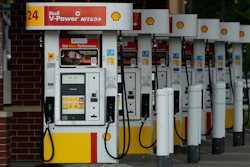 Row of Shell V-Power Nitro+ fuel pumps at gas station with yellow and red accents
