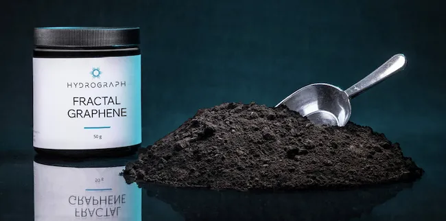 Hydrograph Fractal Graphene powder in white jar with metal scoop on dark teal background