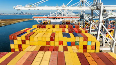 Colorful shipping containers stacked on cargo ship at busy port terminal with cranes and equipment