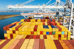 Colorful shipping containers stacked on cargo ship at busy port terminal with cranes and equipment