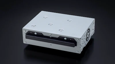 White metal industrial enclosure with black front panel, ventilation holes, and mounting fasteners on dark background
