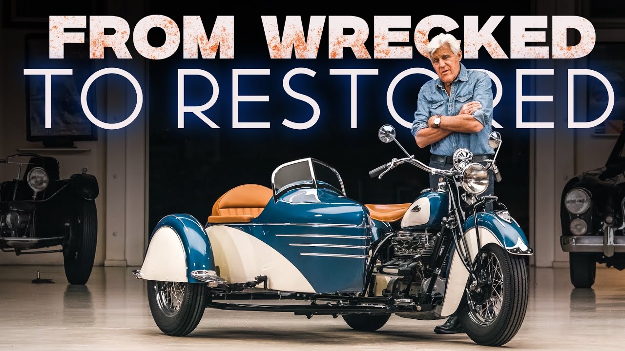 Restored blue and white motorcycle with sidecar and man in workshop setting with 'From Wrecked to Restored' text