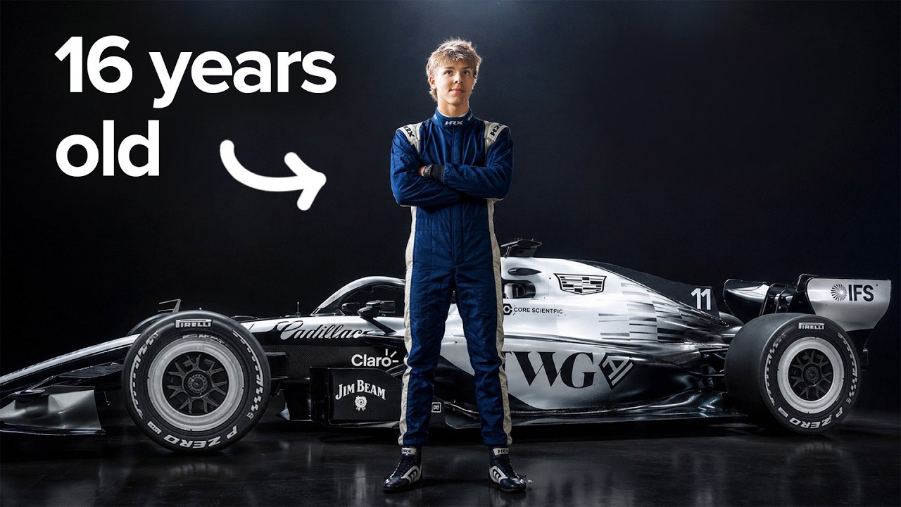 16-year-old racing driver in blue suit standing with arms crossed next to white and black Formula 1 car