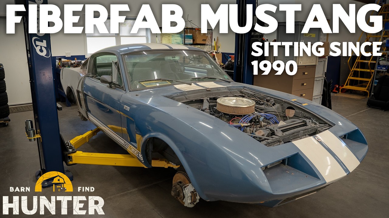 Blue and white Fiberfab Mustang kit car with open hood on lift in workshop, sitting since 1990